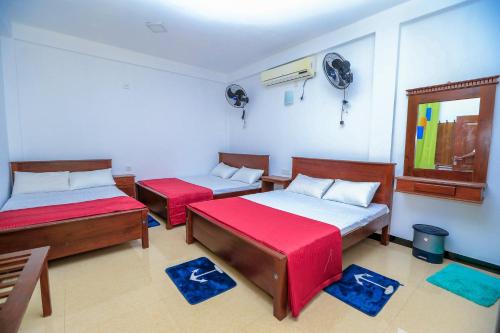 a room with two beds and a fan at Heritage villa polonnaruwa in Polonnaruwa