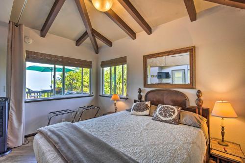 a bedroom with a bed and two windows at Peaceful Milolii Cottage with Ocean and Sunset Views! in Papa Bay Estates