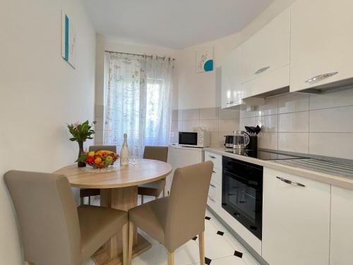 Villa ARINA في توسيبي: مطبخ مع طاولة وكراسي خشبية في الغرفة