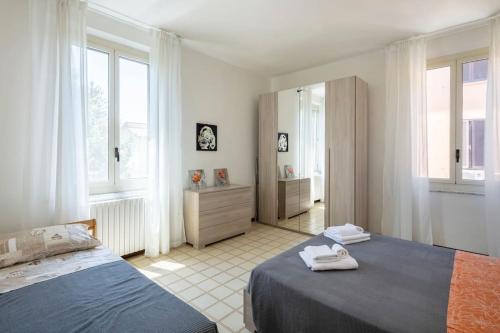 1 dormitorio con 2 camas y espejo en Appartamento vicino Ospedale con self check-in, en Parma