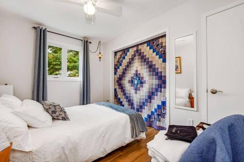 1 dormitorio con 2 camas y una pared de mosaico en Cozy Waterfront Cottage, WiFi-Netflix-Dog Friendly, en Lanark