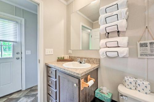 ein Bad mit einem Waschbecken, einem WC und Handtüchern in der Unterkunft Cozy Cassopolis Cabin, Near Parks and Golfing! in Cassopolis