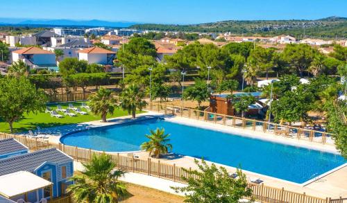 une vue aérienne d'une piscine dans un complexe hôtelier dans l'établissement Cathy & David-Mobile Home 11-Camping Novela, à Port-la-Nouvelle