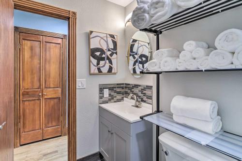 La salle de bains est pourvue d'un lavabo et d'une étagère avec des serviettes. dans l'établissement Denver Capitol Hill Townhome with Fenced Yard!, à Denver