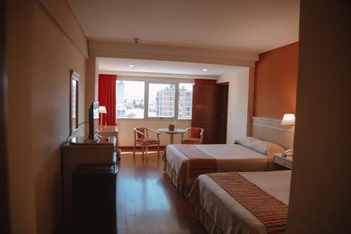 um quarto de hotel com duas camas e uma mesa em Casa Real Hotel em Salta