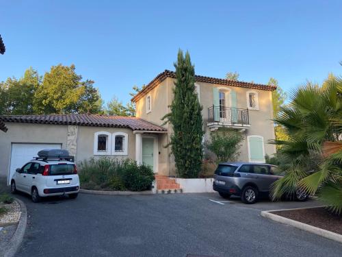 a house with two cars parked in a parking lot at Fayence Villa with private pool in Fayence