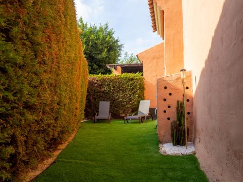 a garden with two chairs and a hedge at Jardín privado # Netflix # 500m de la playa in Vera