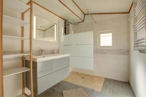 une salle de bain blanche avec un lavabo et un miroir dans l'établissement Maison 8 couchages Arès, à Arès