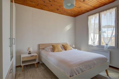 une chambre blanche avec un lit et une fenêtre dans l'établissement Maison 8 couchages Arès, à Arès