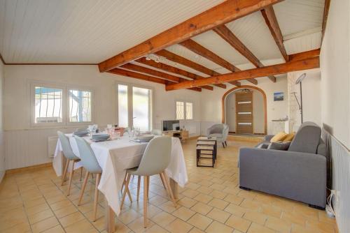 une salle à manger avec une table et un canapé dans l'établissement Maison 8 couchages Arès, à Arès