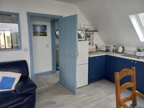 a kitchen with blue cabinets and a white refrigerator at Blue Pearl Apartment in Downings