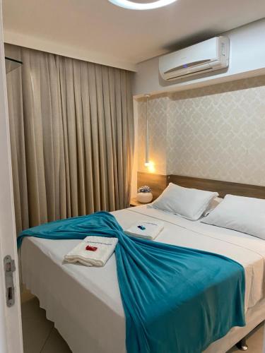 a bedroom with a large bed with a blue blanket at Landscape Beira Mar Deluxe Vista Mar in Fortaleza