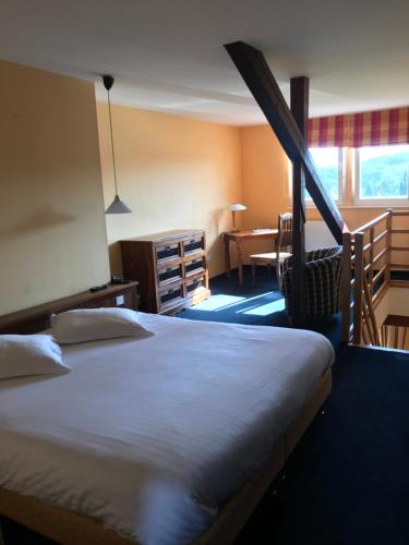 a hotel room with a large bed and a table at La Belle Vue in Saulxures
