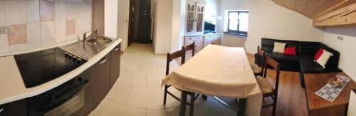 eine Küche mit einem Tisch, Stühlen und einem Waschbecken in der Unterkunft Appartamenti Callori Karin Codici Cipat 22039-AT-53550 AT-53551 in Canazei