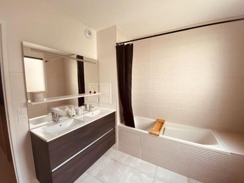 a bathroom with a tub and a sink and a bath tub at Disneyland Dream 5 - Charmante Maison 10 pax in Chessy