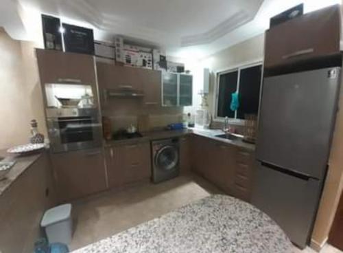 a small kitchen with a refrigerator and a dishwasher at Résidence diamant vert 7 sidi Bouzid in Sidi Bouzid
