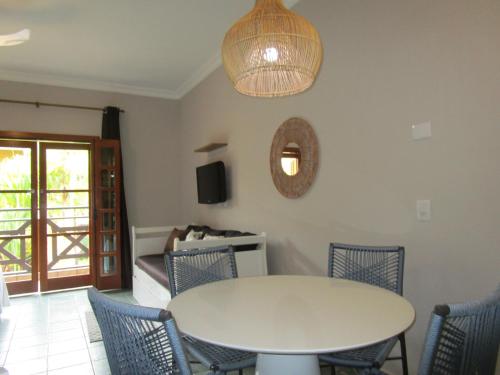 a dining room with a white table and chairs at Ilha Flat Hotel Suíte Bella - 4207 - Ilhabela in Ilhabela