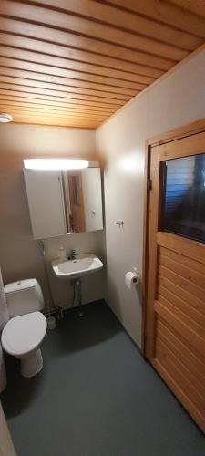 ein Bad mit einem WC, einem Waschbecken und einem Fenster in der Unterkunft Huoneisto Riekko in Suomussalmi