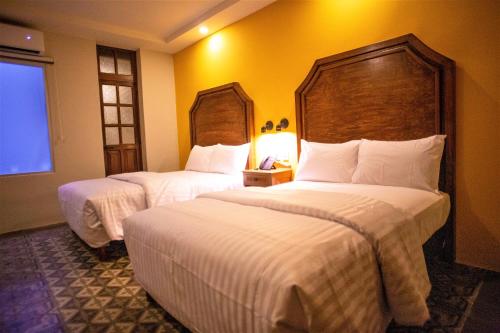 a hotel room with two beds and a window at Hotel Real Toledo by Kavia in Mérida