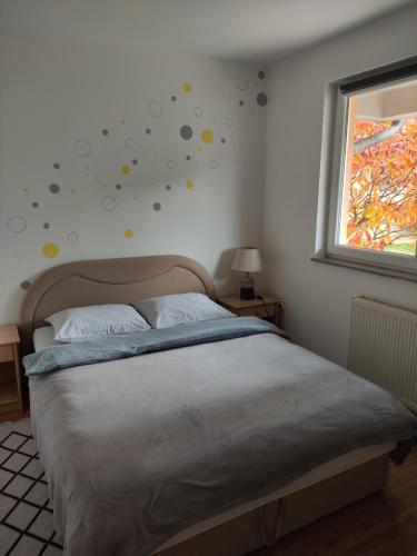 um quarto com uma cama e uma janela com pontos na parede em Apartman Marija, Lukavica, Istočno Sarajevo em Lukavica