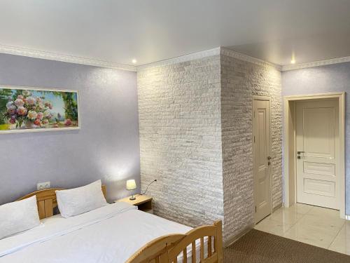 a bedroom with a bed and a brick wall at Park Hotel in Umanʼ