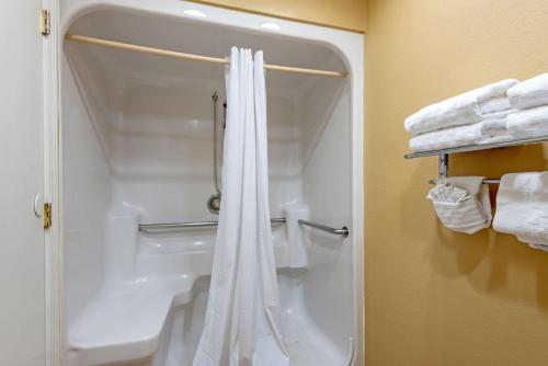 a white shower curtain in a bathroom with towels at Best Western Turquoise Inn & Suites in Cortez