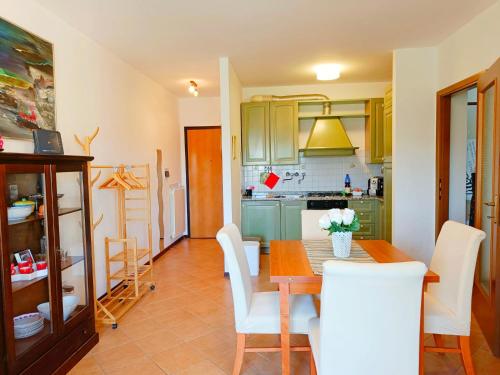 a kitchen with a wooden table and white chairs at [Siena] Appartamento con splendido terrazzo in Presciano