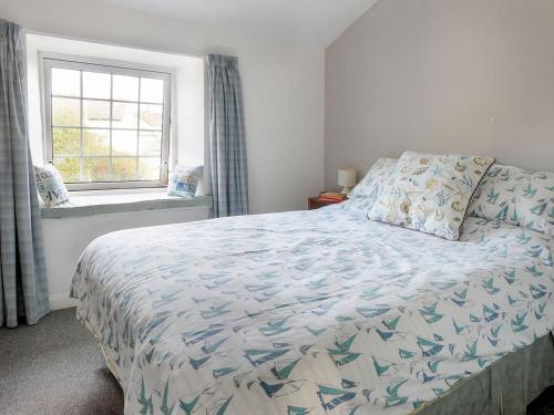 a bedroom with a bed and a window at Tremar in Saint Martins Green