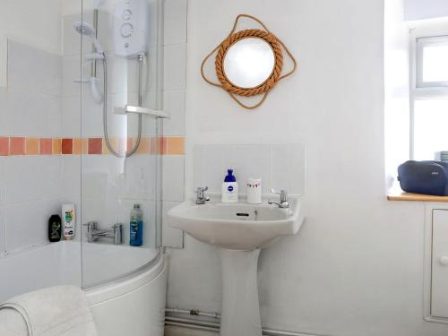 a white bathroom with a sink and a shower at Tremar in Saint Martins Green