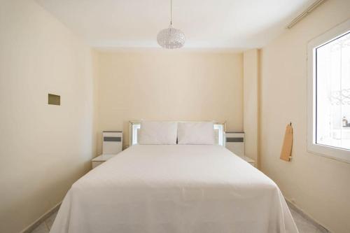- un lit blanc dans une chambre blanche dotée d'une fenêtre dans l'établissement BODRUM BURCU RESIDENCE, Magnificent Sea View, Cozy, Free Otopark, Free Wifi, à Bodrum City
