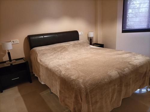 a bedroom with a large bed with a leather headboard at El sol Espanol in Torrox Costa