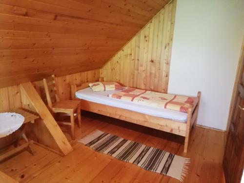 1 dormitorio con 1 cama en una cabaña de madera en Demény vendégház en Sub Cetate
