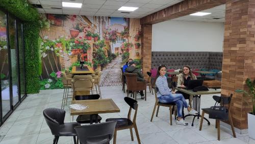 un grupo de personas sentadas en mesas en un restaurante en Hostel Aurora, en Požarevac