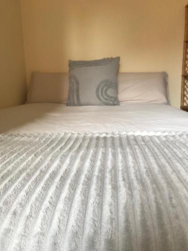 Una cama blanca con una almohada encima. en Apartamento Haro Wine Experience, en Haro