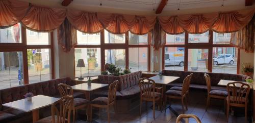 a restaurant with tables and chairs and windows at Pension Jung, Bäckerei-Konditorei & Café in Ruhla