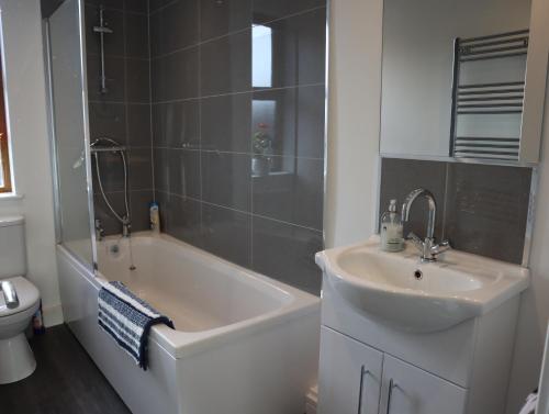 a bathroom with a tub and a sink and a toilet at Sheffield 3-bedroom house with free street parking in Sheffield