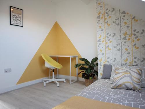 a bedroom with a bed and a yellow chair at Sheffield 3-bedroom house with free street parking in Sheffield