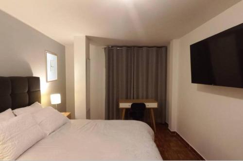 Habitación de hotel con cama y TV de pantalla plana. en Gorgeous Private Studio LIMA-Own Bathroom-Near Airport, en Lima