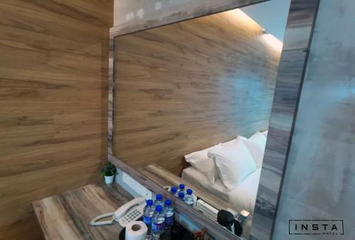 a small bed in a room with a wooden wall at Insta Hotel JB in Johor Bahru