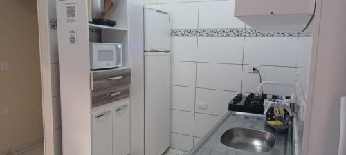 una pequeña cocina con fregadero y microondas en Costa house, en Penha