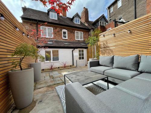 a patio with a couch and a table and a house at Georgian 3 bed house in historic town centre in Shrewsbury