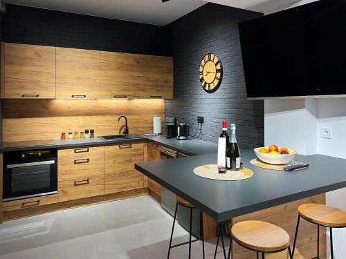 a kitchen with wooden cabinets and a table with a bowl of fruit at Prestige 12 in Zator