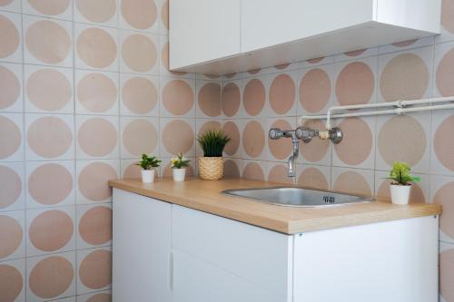 a kitchen with a sink and pink circles on the wall at Loft in Centro con Camino - Sestola in Sestola