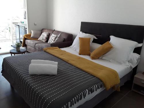 a large bed in a room with a couch at La Perle du Rocher in Le Diamant