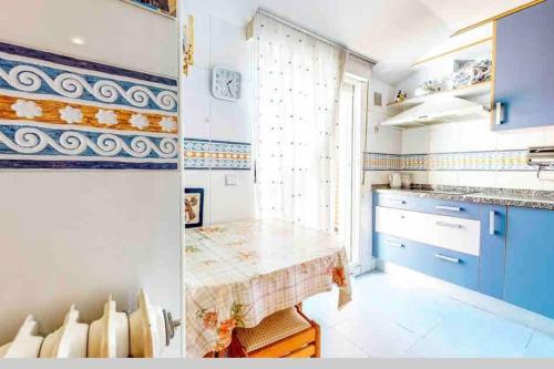 two pictures of a kitchen with blue cabinets and a table at La Casa del impresor in Avila