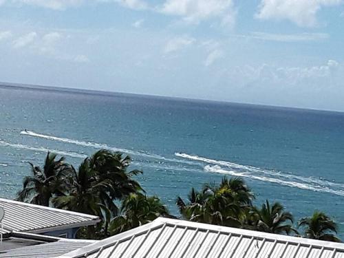 a view of the ocean from a resort at La Perle du Rocher in Le Diamant