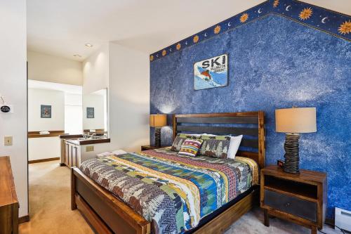 a bedroom with a blue accent wall at Sunrise Highlander L2 in Killington