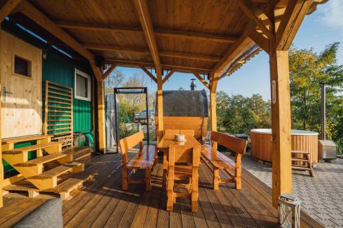 a wooden deck with a wooden table and chairs at Maringotka Olívie v Ivančicích in Ivančice