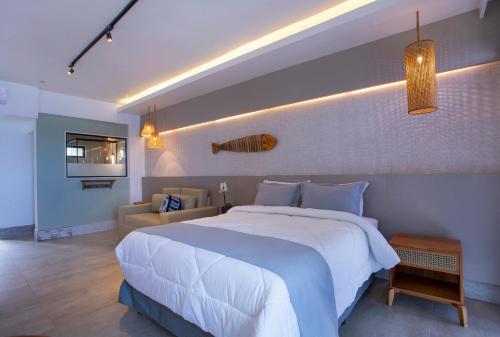 sypialnia z dużym białym łóżkiem i kanapą w obiekcie Hotel Village Enseada w mieście Ubatuba