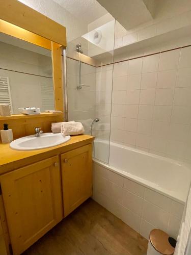 une salle de bain avec un lavabo et une baignoire dans l'établissement Au Petit Flocon - Appartement 3 pièces, central et proche pistes - parking privé et wifi, à Megève